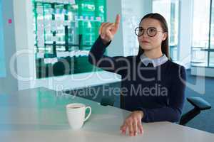 Female executive gesturing at desk