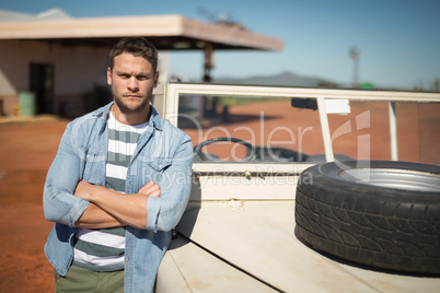 Man standing with arms crossed near his car