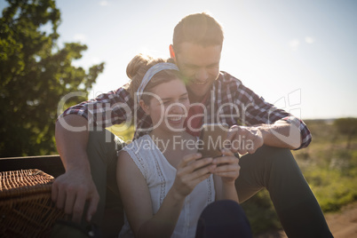 Couple looking at photos on mobile phone in a car
