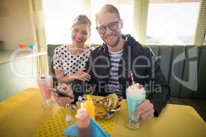 Couple using mobile phone in restaurant