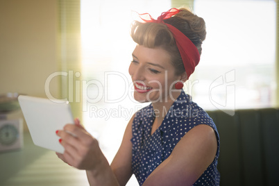 Woman using digital tablet in restaurant