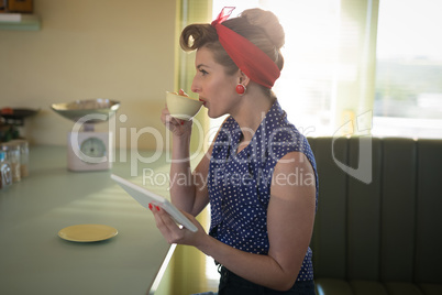Woman having coffee while using digital tablet Woman having coffee while using digital tablet