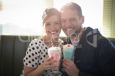 Couple having milkshake in restaurant