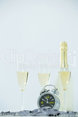 Champagne with alarm clock and glass on white background