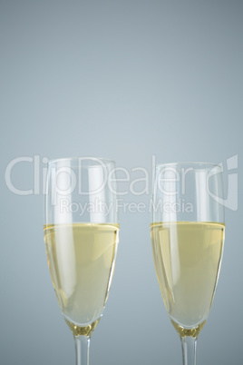 Two champagne flutes against white background