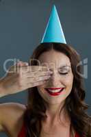Woman in party hat closing her eyes