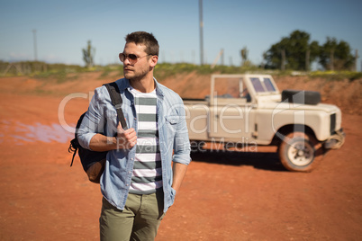 Man in sunglasses standing with his backpack