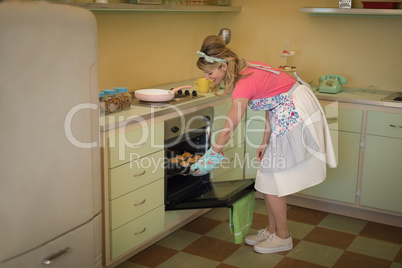 Waitress putting muffins in oven