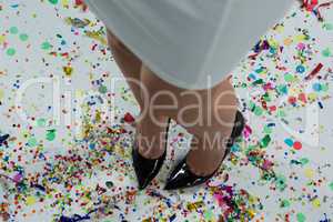 Woman standing wearing black heels standing on the confetties