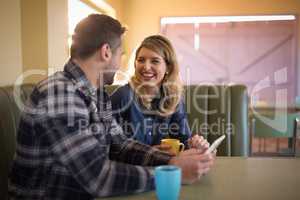 Couple using digital tablet in restaurant