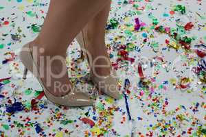 Woman standing wearing beige heels standing on the confetties