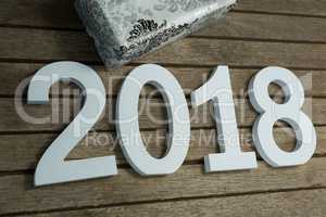 New year number 2018 with gift kept on wooden surface