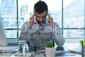 Male executive suffering from headache at desk