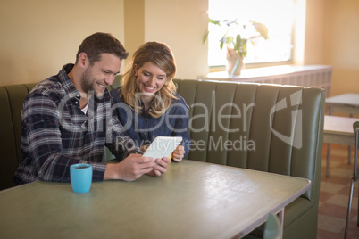 Couple using digital tablet in restaurant