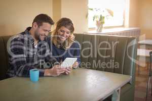 Couple using digital tablet in restaurant