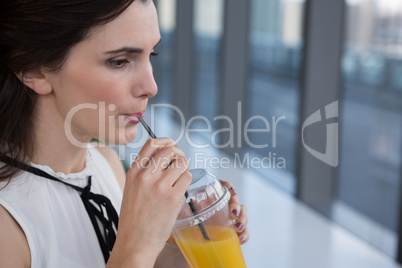 Female executive having drink in futuristic office