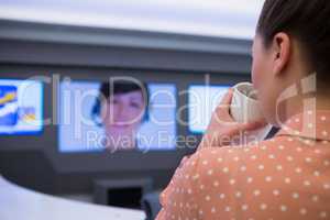 Female executive having coffee during video call