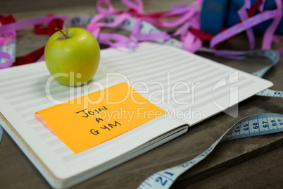 Diary with new year resolution join a gym and measuring tape