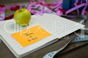 Diary with new year resolution join a gym and measuring tape