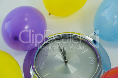 Balloons and clock hands reaching 12 o clock midnight