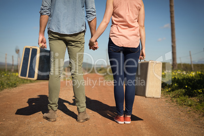 Couple walking with their luggage on a sunny day Couple walking with their luggage on a sunny day
