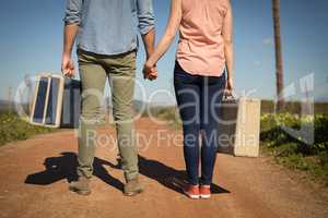 Couple walking with their luggage on a sunny day