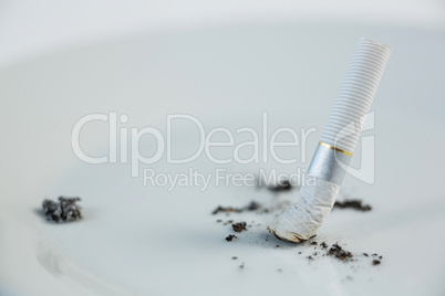 Single cigarette butt with ash isolated on white background