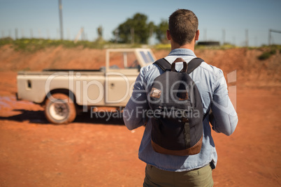 Man standing with his backpack on a sunny day