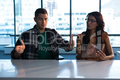 Male and female executive using digital invisible screen