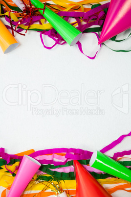 Colorful streamers and party hat on white background