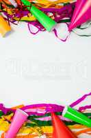 Colorful streamers and party hat on white background