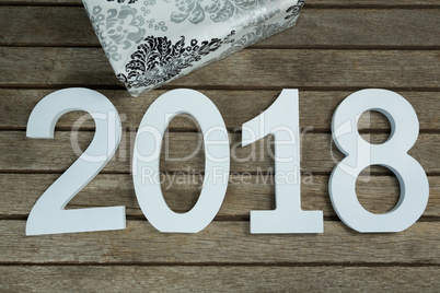 New year number 2018 with gift kept on wooden surface