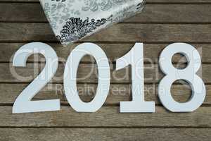 New year number 2018 with gift kept on wooden surface
