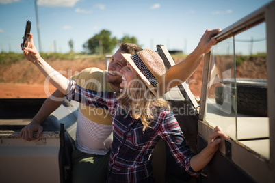 Couple taking selfie with mobile phone in a car