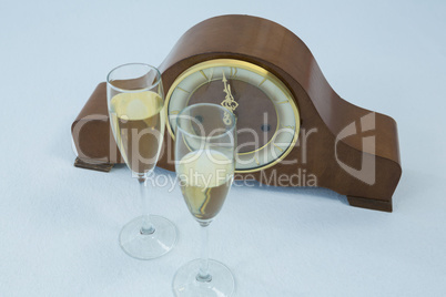 Champagne glass and clock on white background