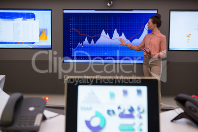 Female executive giving presentation on graph