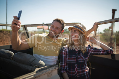 Couple taking selfie with mobile phone in a car