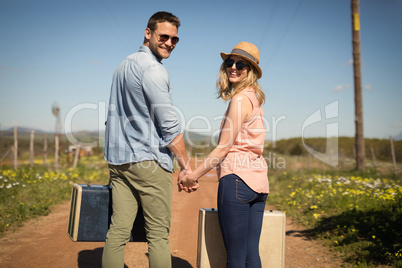 Couple walking with their luggage on a sunny day