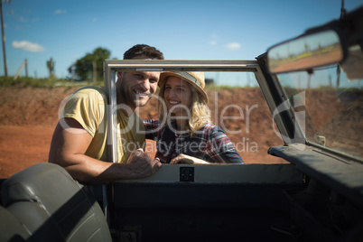 Couple romancing together behind a car