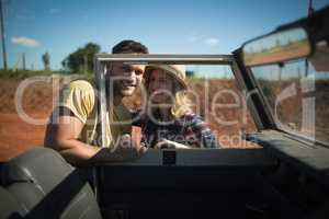 Couple romancing together behind a car