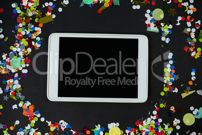 Digital tablet surrounded by confetti