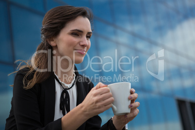 Female executive having coffee in office premises