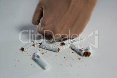 Woman breaking cigarette with fist