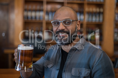 Smiling man having glass of beer in restaurant