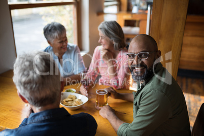 Man having glass of beer with friends in bar