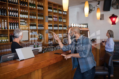 Man ordering a wine bottle at bar counter