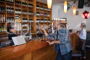 Man ordering a wine bottle at bar counter