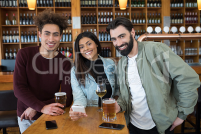 Smiling friends having drinks in bar