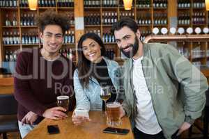 Smiling friends having drinks in bar