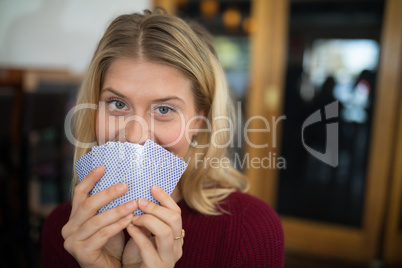 Beautiful woman holding cards in bar